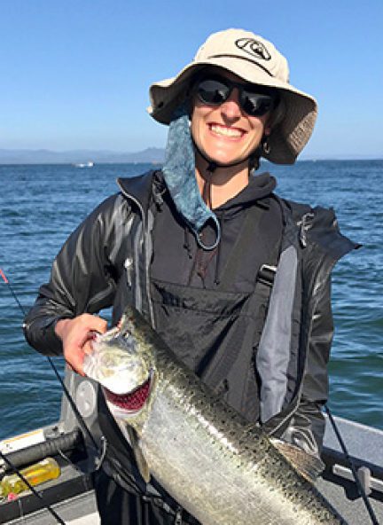 A fishing woman holding a salmon